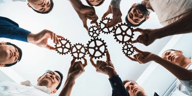 gears A group of people holding up gears in the shape of a circle.